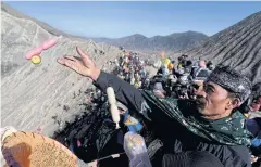  ??  ?? BELOW
A Hindu worshipper throws offerings into the volcanic crater of Mount Bromo in East Java.