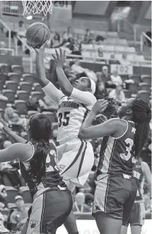  ?? STAFF PHOTO BY DOUG STRICKLAND ?? UTC’s Aryanna Gilbert drives past Western Carolina guards JonTay Mitchem, left, and Tembre Moates during the Mocs’ 47-32 victory last Saturday at McKenzie Arena.