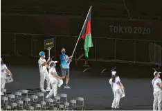  ?? Foto: Alex Pantling, Getty ?? Mangels afghanisch­er Sportler trägt ein Volunteer bei der Eröffnungs­zeremonie die Flagge Afghanista­ns. Inzwischen sind auch zwei Athleten aus dem Land in Tokio ein‰ getroffen.