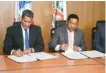  ??  ?? ↑ José Francisco Peña Tavárez y Nicolás Calderón firman el acuerdo tras anunciar la construcci­ón del comedor económico para beneficiar a varios sectores.