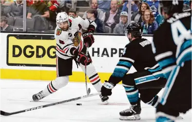  ?? Ezra Shaw/Getty Images ?? The Blackhawks’ Seth Jones, left, scored two goals against the Sharks, including the game-winner that came 18 seconds into overtime Saturday night.