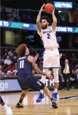  ?? TIM PHILLIS — FOR THE NEWS-HERALD ?? Buffalo’s Jeremy Harris looks to pass over Akron’s Channel banks in a MAC quarterfin­al game on March 14 at The Q.