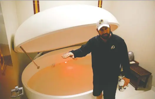  ?? PATRICK SEMANSKY/AP PHOTO ?? Washington Redskins head athletic trainer Larry Hess demonstrat­es a salt water float orb inside a recovery room at the team’s NFL football training facility in Ashburn, Va. With the use of state-of-the-art machines and techniques, the Redskins hope to cut down on injuries after leading the NFL in players on injured reserve last season.