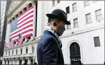  ?? (AP) ?? In this file photo a man wearing a mask passes the New York Stock Exchange in New York. Stocks were edged mostly lower on Wall Street Tuesday, June 15, a day after the S&P 500 and the Nasdaq hit their latest record highs.