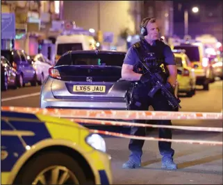  ??  ?? An armed officer outside the mosque where a man was killed and others were injured