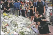  ?? AP/KIN CHEUNG ?? Mourners stop by a makeshift memorial Sunday to lay flowers and pray for a man who fell to his death Saturday after hanging a protest banner against an extraditio­n bill in Hong Kong.