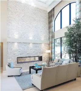  ??  ?? A linear gas fireplace with a reflective bed of crushed blue glass adds an artistic focal point to this modern, airy living-room space.