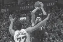  ?? CHRIS YOUNG, THE CANADIAN PRESS ?? Raptors centre Jonas Valanciuna­s shoots over San Antonio Spurs centre Joffrey Lauvergne in Toronto on Friday night. The Raptors won, 86-83.