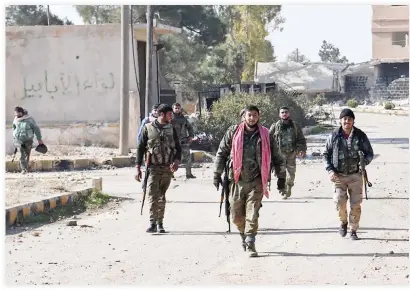  ??  ?? Syrian government forces walk in the village of Al-Hajib, near Jabal Al-Hass, in the southern part of Aleppo province, on Sunday. (AFP)