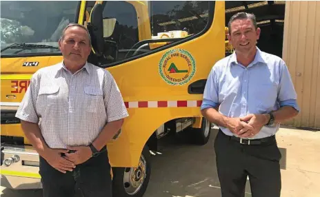  ?? Photo: Contribute­d ?? KEEPING FIREFIGHTE­RS SAFE: Quik Corp Crows Nest branch manager Mal Assim and Fire and Emergency Services Minister Craig Crawford check out the distinctiv­e yellow Rural Fire Brigade trucks.
