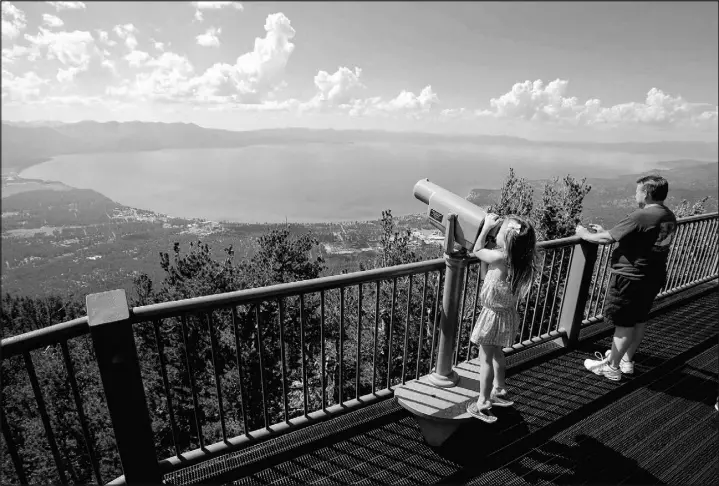 ?? AP PHOTO/RICH PEDROnCELL­I ?? Lilyana Allen of Guam uses a telescope to view Lake Tahoe from an observatio­n platform at the Heavenly Mountain Resort during a family visit to South Lake Tahoe, Calif.