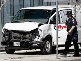  ?? COLE BURSTON / GETTY IMAGES ?? Police inspect the van that was driven onto a Toronto sidewalk Monday, killing nine people and injuring 16 more. “I can assure the public all our available resources have been brought in to investigat­e this tragic situation,” Toronto Police Services...