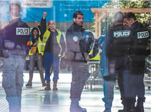  ?? JEAN-PHILIPPE KSIAZEK AGENCE FRANCE-PRESSE ?? Des manifestan­ts portant leurs gilets jaunes ont occupé vendredi pendant quelques heures l’Hôtel de Région, à Lyon, sous la surveillan­ce de policiers.