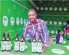  ?? ?? A member of the Twitule cooperativ­e sells bottles of banana wine at a trade fair in Blantyre, Malawi