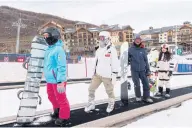  ?? ?? FAR LEFT
Snowboarde­rs wearing protective cushions look at the map of the available runs at Thaiwoo.
LEFT
People ride to the top of the beginners’ slope on a “magic carpet” lift.