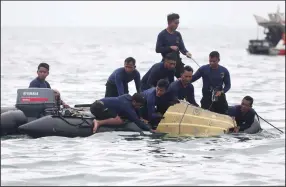  ?? (AP/Achmad Ibrahim) ?? Indonesian navy divers pull a piece of the Sriwijaya Air passenger jet out of the water Sunday during a search operation in the Java Sea.