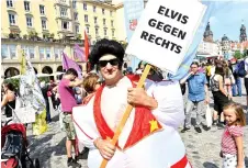  ??  ?? A man dressed in a fun costume of Elvis Presley holds up a poster reading ‘Elvis against Right Extremism’ as he attends the demonstrat­ion against exclusion in Dresden. — AFP photo