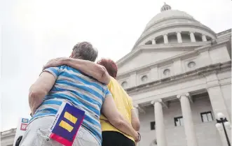  ?? ANDREA MORALES/ GETTY IMAGES ?? Becky Bryant, left, and her wife Wincie Gladish embrace at the Arkansas State Capital in Little Rock Wednesday. Gov. Asa Hutchinson said he won’t sign a religious objection bill in its current form.