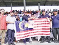  ?? (Gambar atas) (Gambar bawah) ?? DURAHIM (dua dari kanan) menyerahka­n Jalur Gemilang kepada Bolkiah. BOLKIAH melepaskan konvoi kereta dan motosikal pada majlis itu.