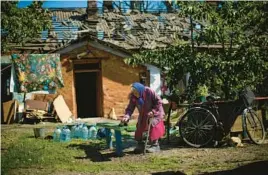  ?? FRANCISCO SECO/AP ?? A resident of the eastern Ukrainian town of Pokrovsk removes dust from a bench outside her heavily damaged house on Wednesday after two Russian rocket strikes.