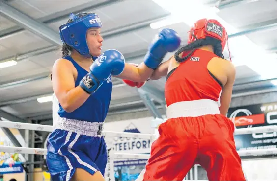  ?? Photos / Lewis Gardner ?? Trinity Albert swings away on Elizabeth Tuifua at the River City Boxing Club’s fight night at the Kaierau Country Club on Saturday.