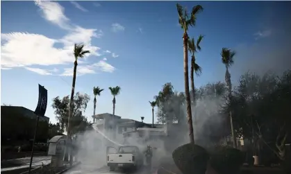  ?? ?? A Phoenix firefighte­r uses a hose line to extinguish a pickup truck that caught fire during theheatwav­e. Photograph: Patrick T Fallon/AFP/ Getty Images