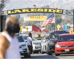  ??  ?? Supporters of President Donald Trump demonstrat­ed along the route of the Black Lives Matter caravan that drove through downtown Lakeside.