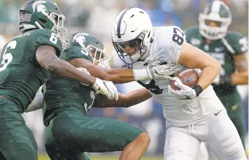  ?? AL GOLDIS/AP ?? Penn State tight end Pat Freiermuth, right, bulls his way past Michigan State’s Xavier Henderson (3) and David Dowell for a touchdown Saturday.