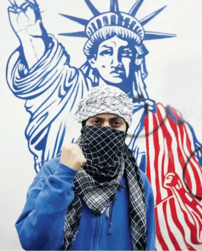  ?? KEYSTONE ?? Un iraniano davanti a un murale con la Statua della Libertàdan­neggiata