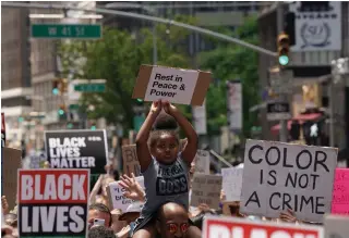  ?? BRYAN R. SMITH AFP/GETTY IMAGES ?? A child holds up a sign in New York City on Sunday at a protest over the death of George Floyd.