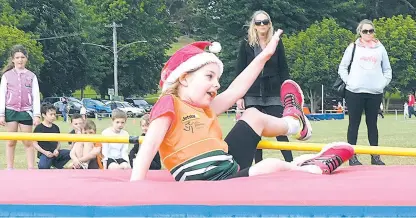  ??  ?? Olivia Boughey, pictured attempting to clear the bar in the high jump, got into the Christmas spirit by wearing a Santa hat to Warragul Little Athletics Centre’s final meet for the year; Photgraphs: Paul Cohen.