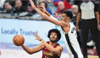  ?? – reuters ?? Where’s the basket?: Cleveland Cavaliers’ Jarrett allen (left) trying to shoot past san antonio spurs’ Victor Wembanyama during their nba game on sunday.