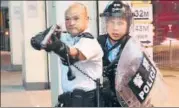  ?? REUTERS ?? A police officer points a gun towards pro-democracy protesters who surrounded a police station in Hong Kong.