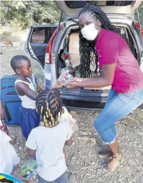  ??  ?? Ashanti James hands out gifts to a group of children.