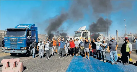  ?? RTR ?? Enojo. Un grupo de camioneros bloquea una ruta en Iquique como protestas, con apoyo de las cámaras empresaria­s por la violencia.