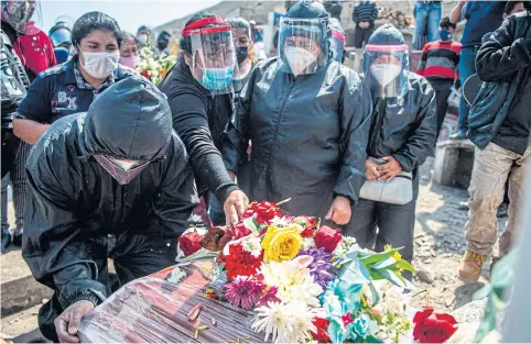  ??  ?? Relatives of a Covid-19 victim mourn during a funeral at a graveyard in Comas, in the northern outskirts of Lima on Wednesday. The pandemic has killed more than 700,000 people worldwide since it surfaced in China late last year.