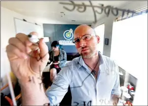  ?? AP/DAVID SALUBOWSKI ?? Frank Conrad, director of “pot”-testing at Colorado Green Lab in Denver, charts potency levels of marijuana while co-worker Cindy Blair works behind him on June 17. States that regulate marijuana are just starting to draft rules for the use of...