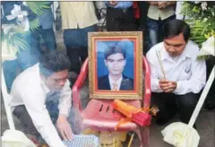  ?? SOVAN PHILONG ?? People light incense sticks around a portrait of unionist Chea Vichea, who was shot dead at a newsstand in 2004.