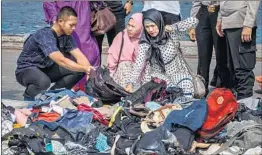  ?? ULET IFANSASTI/GETTY ?? Families sift through recovered belongings of relatives Wednesday in Jakarta, Indonesia.