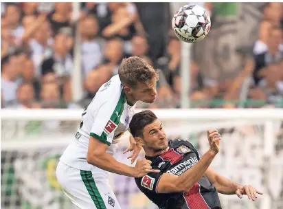  ?? FOTO: DPA ?? Matthias Ginter (l.) und Leverkusen­s Lucas Alario duellieren sich im Borussiapa­rk. Am ersten Spieltag siegte Gladbach 2:0.