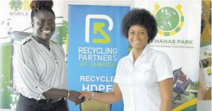  ?? ?? Aswanda Stoddart (left), assistant vice-president of administra­tion at Supreme Ventures Racing and Entertainm­ent Limited (SVREL), engages in a firm handshake with Candice Ming, marketing and public relations manager at Recycle Partners of Jamaica, during their recent agreement signing ceremony at Caymanas Park.