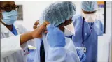  ?? JOHN MINCHILLO—ASSOCIATED PRESS ?? Medical personnel adjust their personal protective equipment while working in the emergency department at NYC Health + Hospitals Metropolit­an, May 27, 2020, in New York.