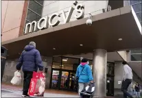  ?? CHARLES KRUPA — THE ASSOCIATED PRESS FILE ?? Shoppers walk to the Macy’s store in the Downtown Crossing district last month in Boston. Americans slowed their spending in November but they showed another month of resilience against higher prices and shortages in stores.