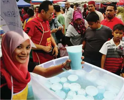  ??  ?? Tea time: Mohd Fahmi and his business partner Nurul Ashikin Abu Talib manning their Ramadan bazaar stall at the Shah Alam Stadium.