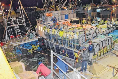  ?? KATHY JOHNSON PHOTO ?? Fishermen work to get the gear off the fishing vessel, The Extreme One, which sank at the Lower East Pubnico wharf on Wednesday, Nov. 28, after an exhaust malfunctio­n.