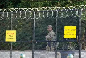  ?? (AP/J. Scott Applewhite) ?? A National Guardsman keeps watch Wednesday along Constituti­on Avenue in Washington where heightened security remains since the Jan. 6 attacks by a mob of supporters of then-President Donald Trump.