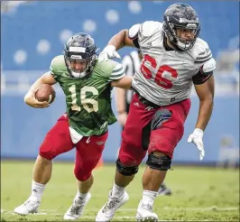  ?? ALLEN EYESTONE / THE PALM BEACH POST ?? FAU quarterbac­k Rafe Peavey (16) follows offensive lineman Will Tuihalamak­a during an Owls scrimmage Saturday in Boca Raton.