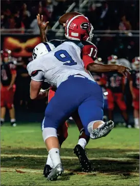  ??  ?? Cade Nayadley crunches Sonoravill­e quarterbac­k Patrick Moore during Friday night’s game. The Tigers picked up a big 31-28 victory in the Region 6-AAA crossover contest. (Photo by Courtney Couey/Ringgold Tiger Shots)