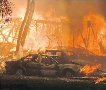  ?? RINGO H.W. CHIU / THE ASSOCIATED PRESS ?? A wildfire rages in Malibu, Calif., Friday. About two-thirds of the city of Malibu was ordered evacuated as a ferocious blaze roared toward the beachside community that is home to about 13,000 residents, including Hollywood stars.