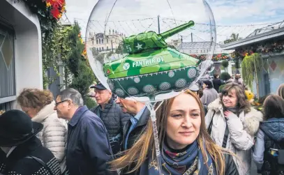  ?? Picture: AFP ?? A woman carries a children’s balloon with a tank inside during an autumn festival held in central Moscow this week.